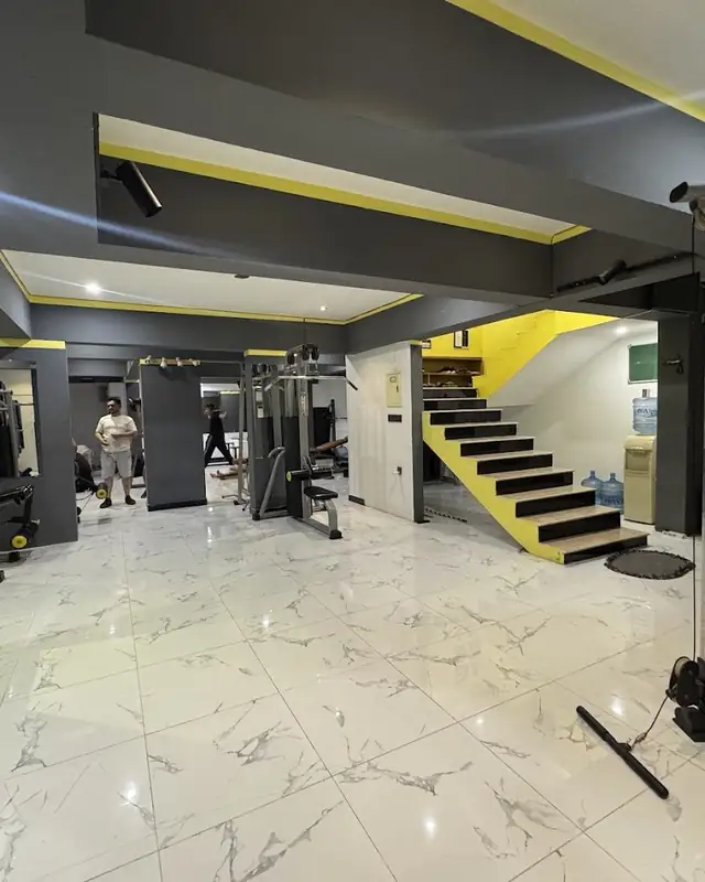 Gym floor with machines and yellow stairs